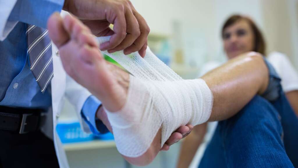dottore fascia il piede ad un paziente con metatarsalgia